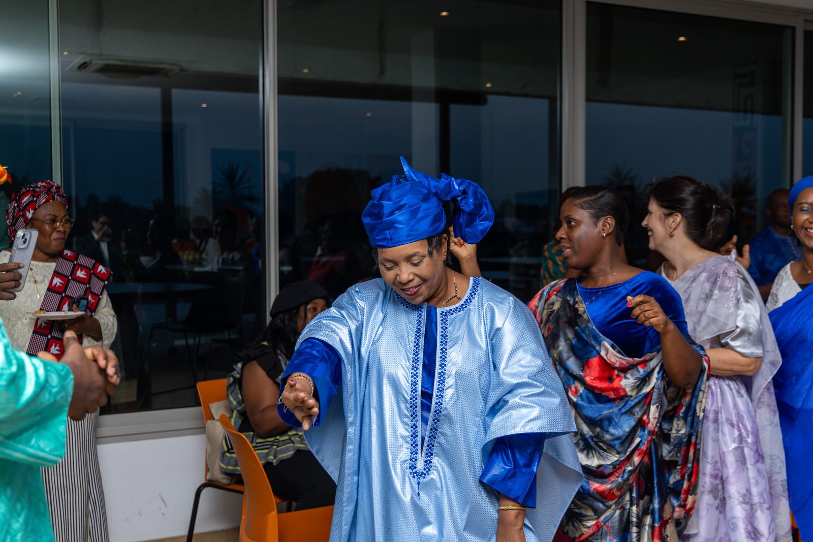 Une invitée en boubou bleu danse au milieu des convives